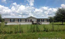 Beautiful 4 bedroom, 2 bath, large mobile home with 2356 heated sq ft on 5.02 acres of land. Home has a large, open plan with hardwood floors throughout. Sits on 1 acre of cleared, fenced in yard with large oak trees. Property also has 2.6 acres of fenced