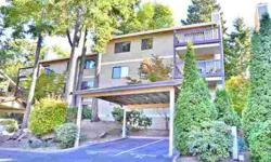 Top floor Kirkland condo with 2 bedrooms, 2 full baths and Peek-a-Boo view of Lake Washington from the generous deck. Enter to vaulted ceilings in the light-filled living space with newer flooring, ceiling fan & masonry fireplace. Kitchen features oak